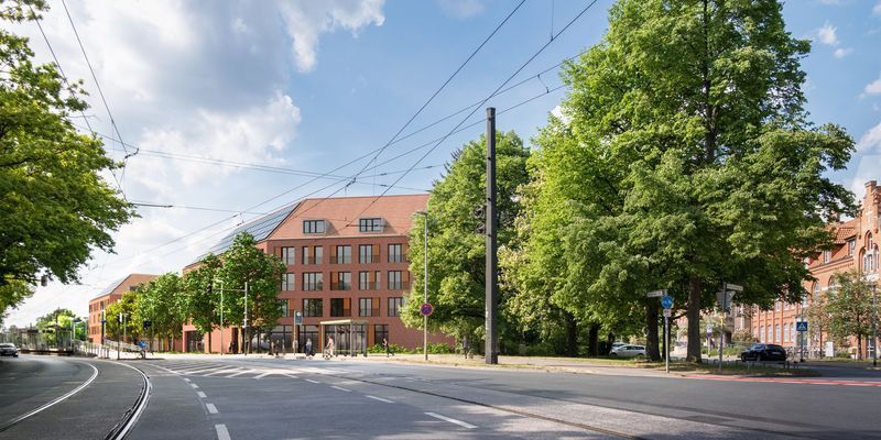Stadtszene mit Straßenbahnschienen, rotbraunes Gebäude und Bäume